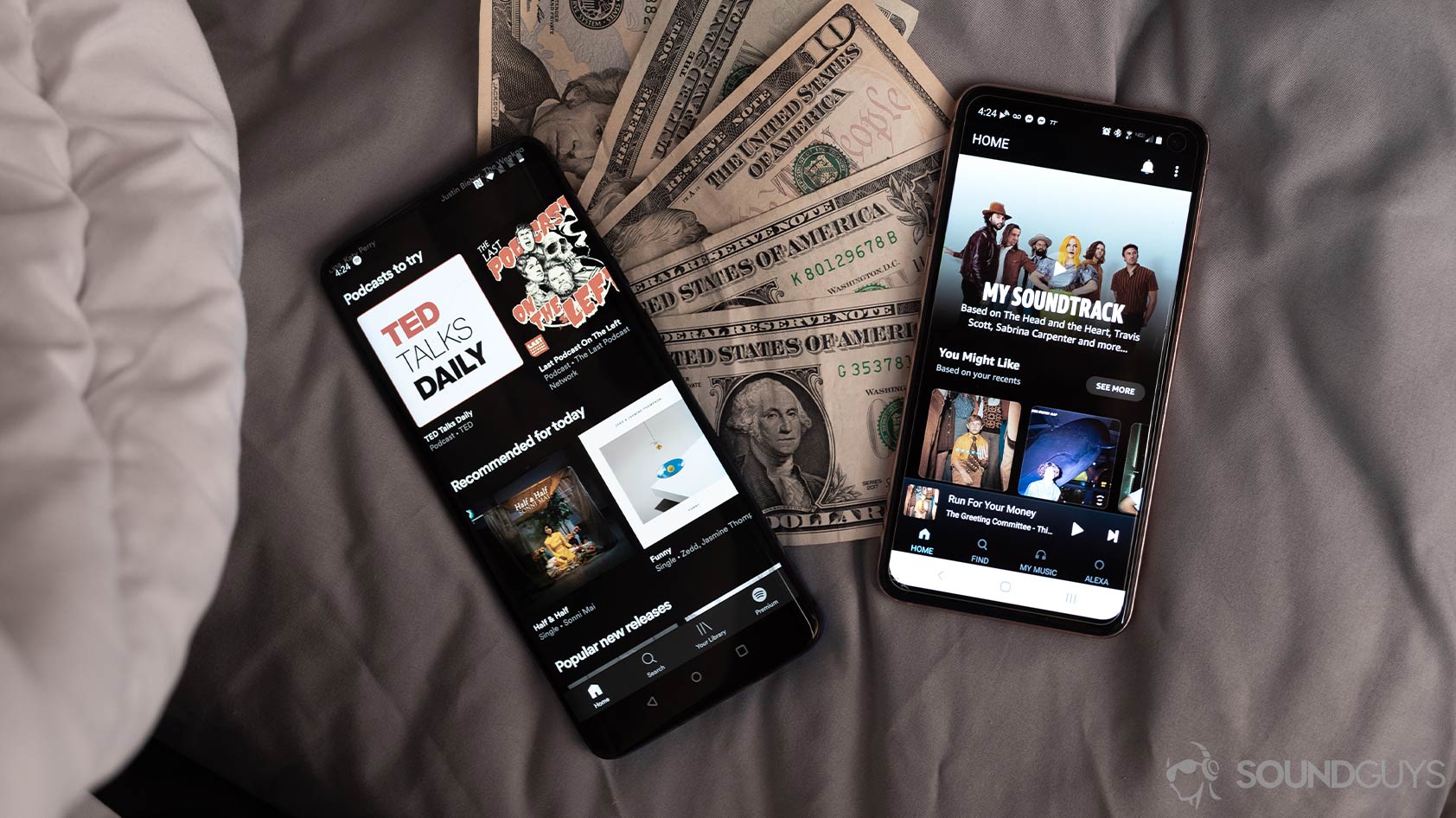 Spotify Premium vs Amazon Music HD on two smartphones laid atop cash.