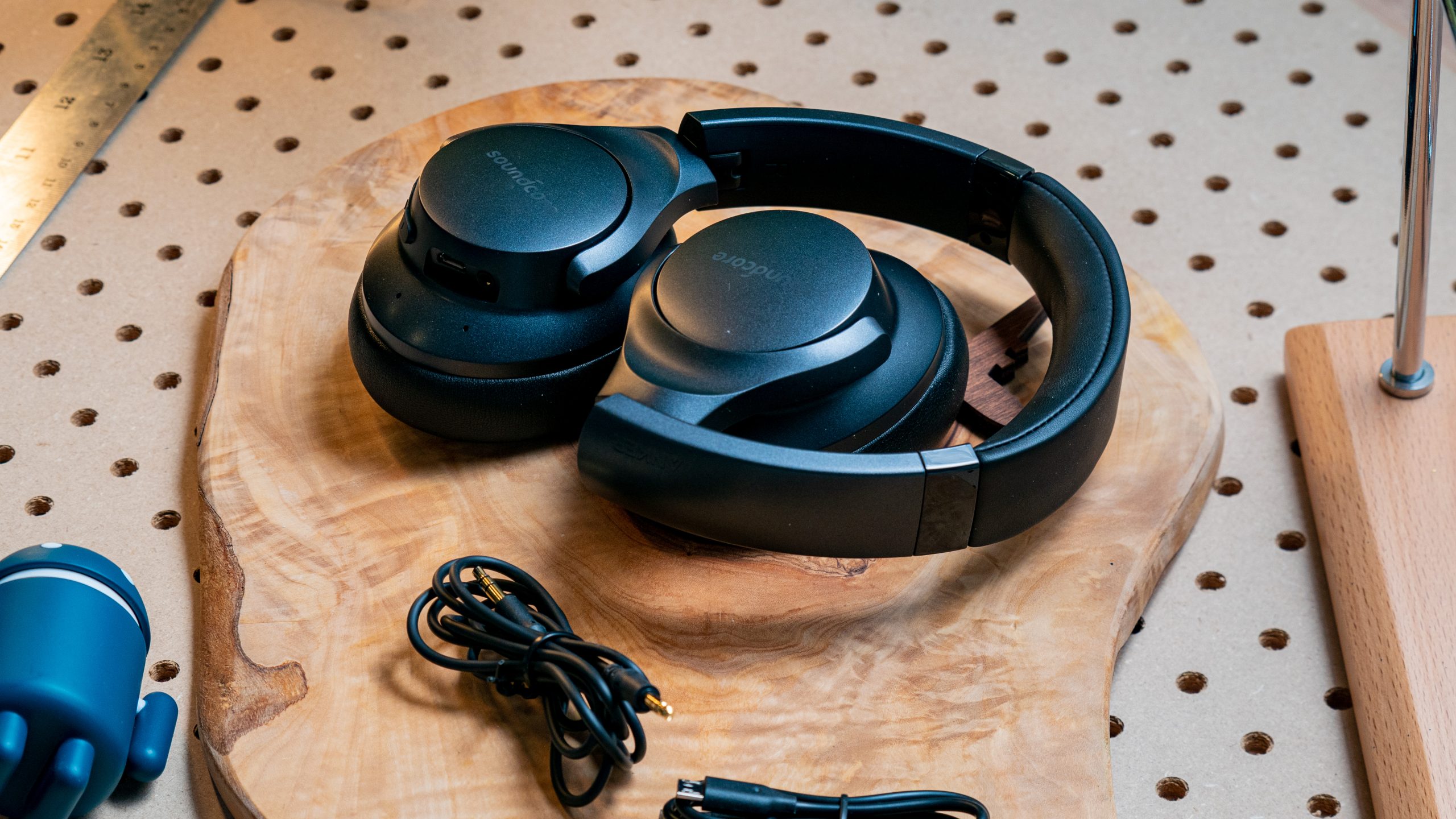 The Anker Soundcore Life Q20 wireless noise canceling headphones and cables on a wood surface.