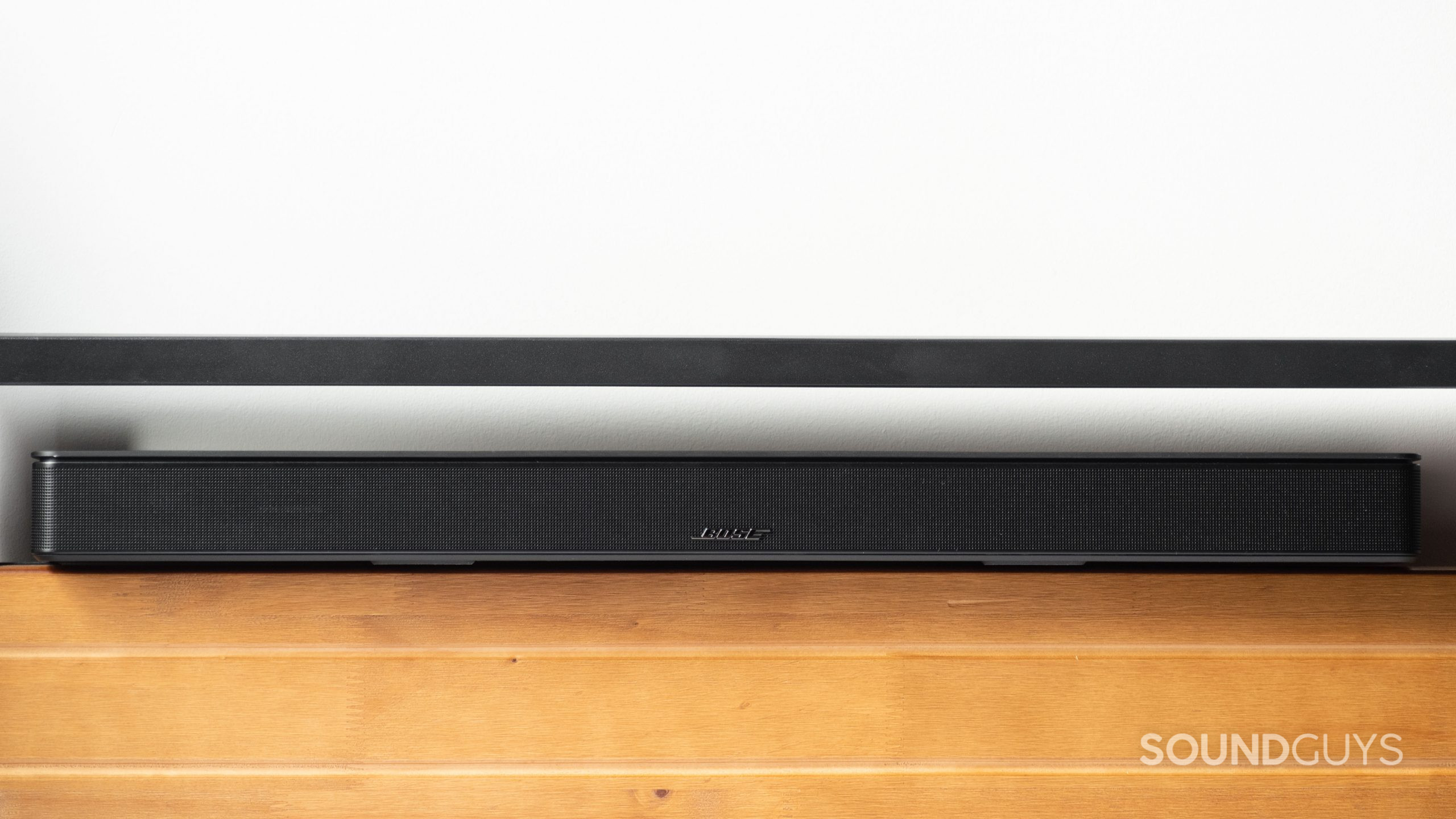 The Bose Smart Soundbar 600 rests on a wooden surface.