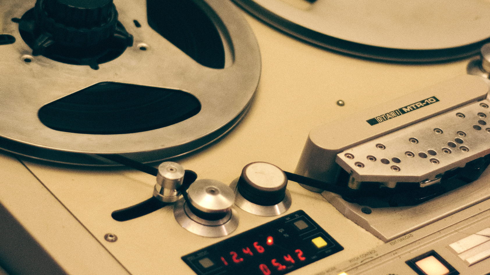 A close up of a reel to reel tape machine showing the display and tape.